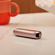 Ploom AURA Rose Gold dipaparkan di atas meja, menyerlahkan tona logam hangat dan reka bentuk minimal serta premium.
