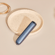 Ploom AURA device positioned on a table featuring a Navy Blue Augmented Pattern front panel, drawing attention to its balanced form and rich finish