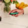 Hand holding a Ploom device with Amazon Green Front Panel, showing comfortable grip, compact design, and a sense of personalized everyday use.