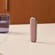 Peranti Ploom dengan Rose Gold Back Cover berdiri di atas meja, menonjolkan kemasan digilap dan estetika harian berinspirasikan kemewahan.
