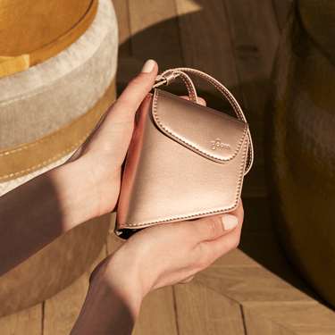 Hand holding a Rose Gold Duo Carry Case accessory, highlighting soft metallic tones, refined design, and a polished, premium feel.