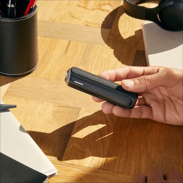 Hand showing a Jet Black Back Cover on a Ploom AURA device, demonstrating smooth design and easy personalization for daily routines
