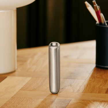 Ploom AURA Lunar Silver device shown standing upright, highlighting stability, balance, and discreet heated tobacco design.
